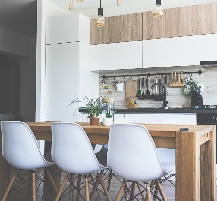 A dining table and open kitchen in a modern residence.